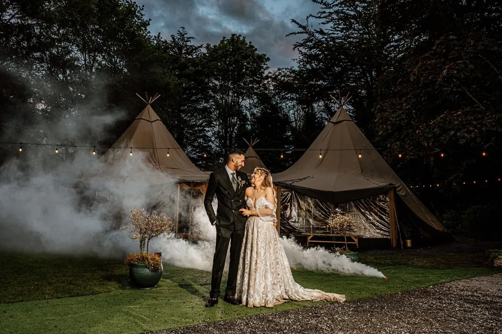 Bride and groom outside the tipis at Brackengarth at dusk