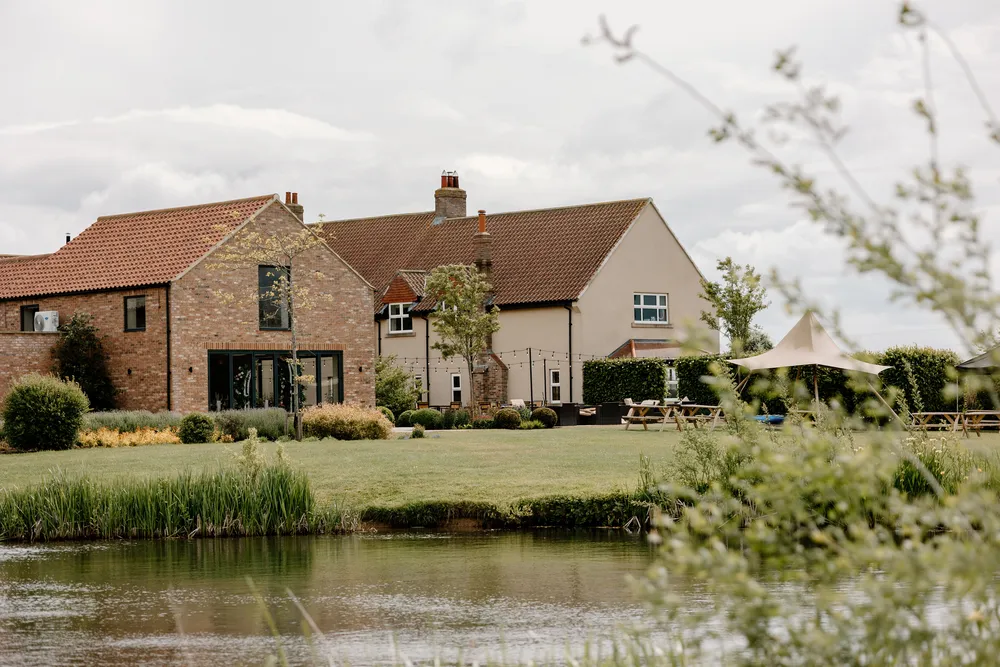 The barn and farmhouse at The Hidden Oak seen across the lake